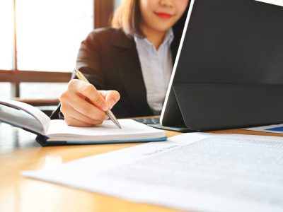 audit business woman working with notebook and tablet on desk.